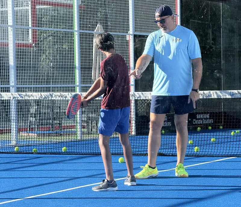 Lezione di padel a un ragazzo sul campo