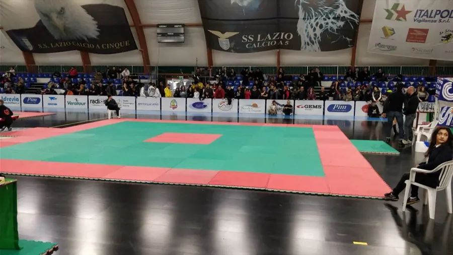 Tatami rosso e verde montato per una gara di Sanda in un palazzetto